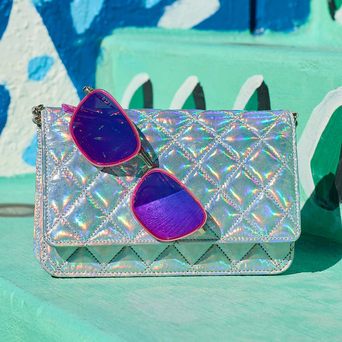 still life - jena sims x diff eyewear the hope cat eye sunglasses with a hot pink and gold frame and hot pink mirror lenses hanging on a purse