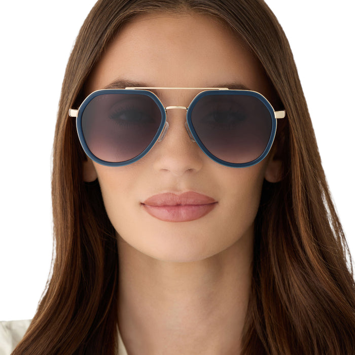 on model - female wearing diff eyewear featuring the joey round sunglasses with a clubhouse blue & brushed gold metal frame with grey gradient lenses front view
