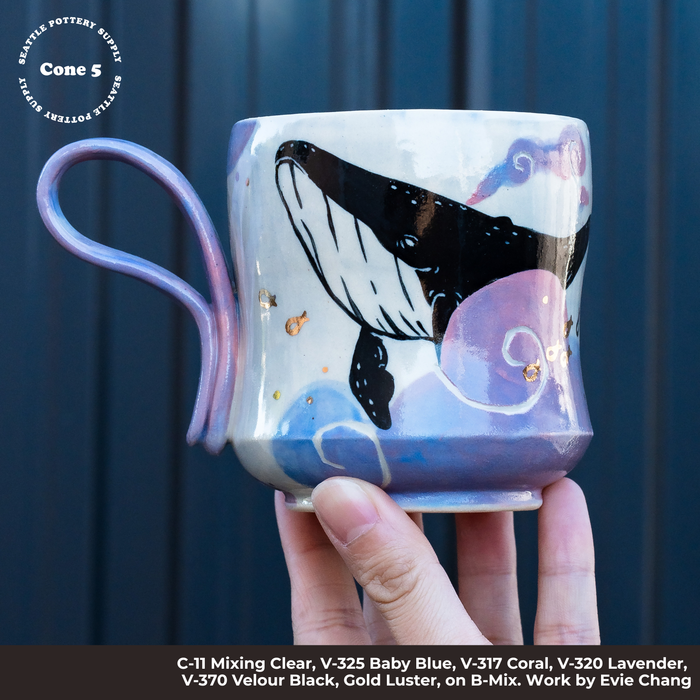Cone 5 mug on B-Mix 5 painted with a black whale over pink and blue swirls, gold luster dots and a lavender handle