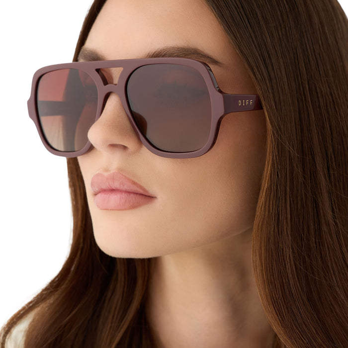 on model - female wearing diff eyewear featuring the layton navigator sunglasses with a rugby red acetate frame and brown gradient polarized lenses detailed view