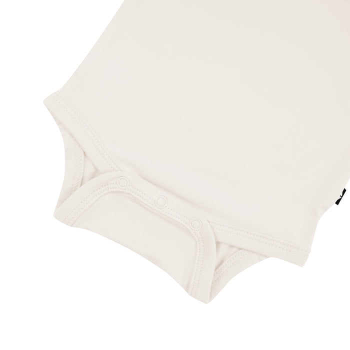 Snap bottom of Kyte Baby Long Sleeve Bodysuit in Oat