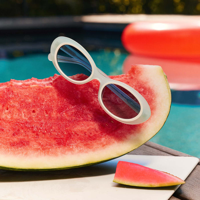 still life - for love & lemons x diff eyewear featuring the sabrina oval sunglasses laying on watermelon next to a pool