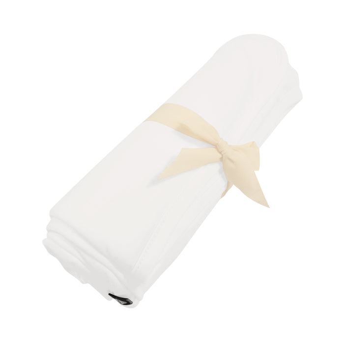 Rolled up Kyte Baby Swaddling Blanket in Cloud with bow tie