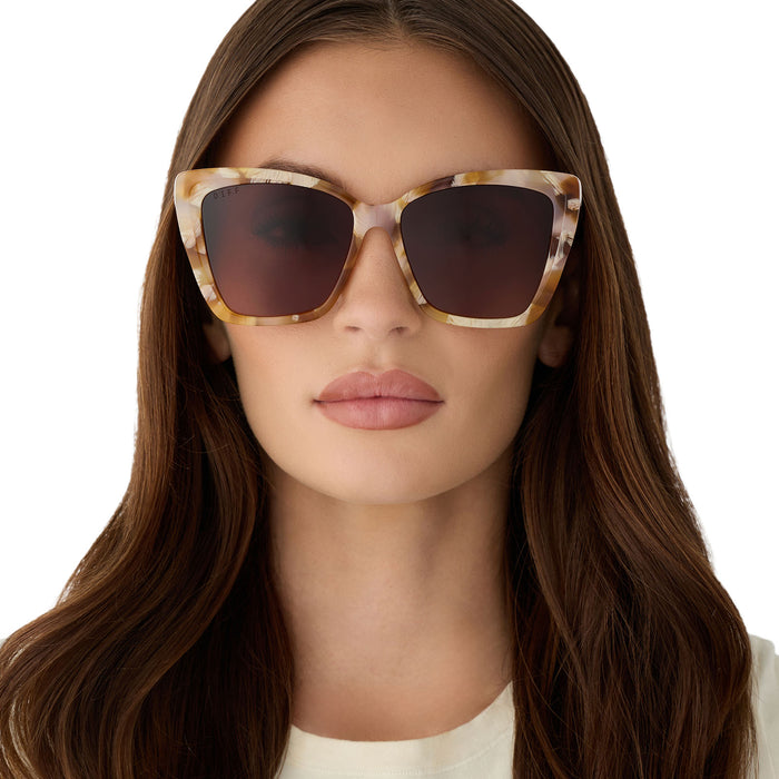on model - female wearing diff eyewear becky ii cat eye sunglasses with a gilded tortoise acetate frame and brown gradient lenses front view
