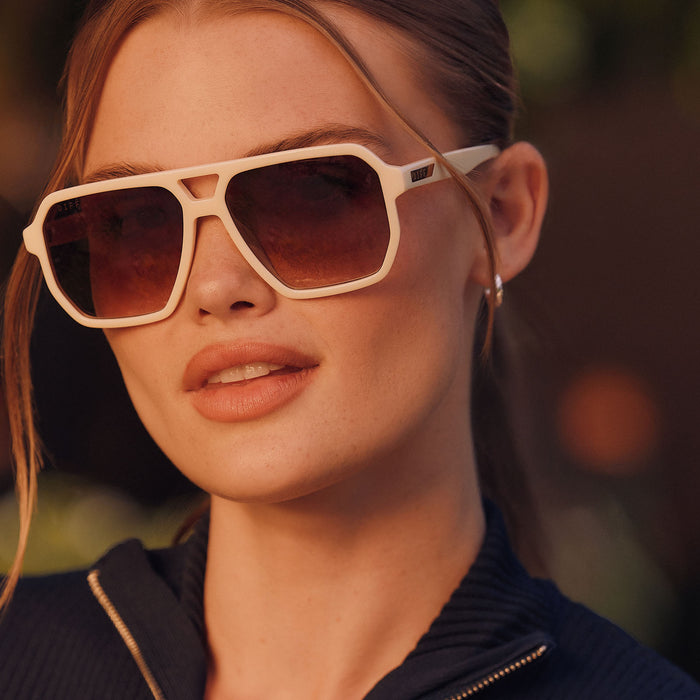 lifesyle -  female wearing diff eyewear featuring the cameron navigator sunglasses with a courtside ivory frame and brown gradient polarized lenses angled view