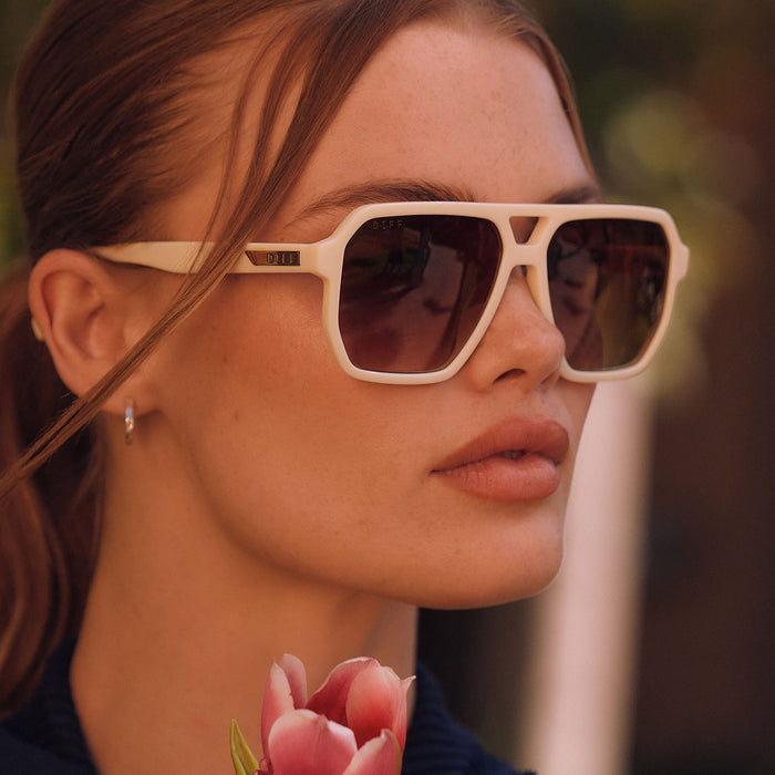 lifesyle -  female wearing diff eyewear featuring the cameron navigator sunglasses with a courtside ivory frame and brown gradient polarized lenses detailed view