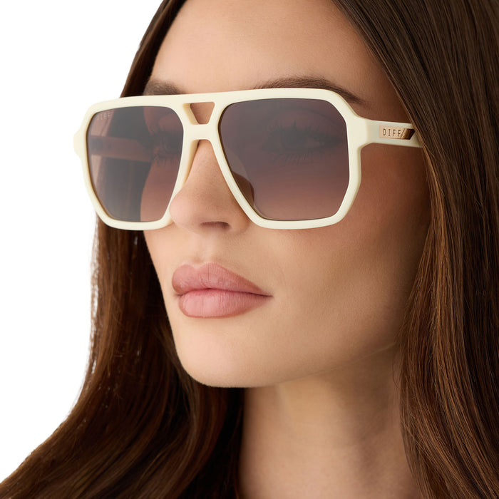 on model - female wearing diff eyewear featuring the cameron navigator sunglasses with a courtside ivory frame and brown gradient polarized lenses angled view