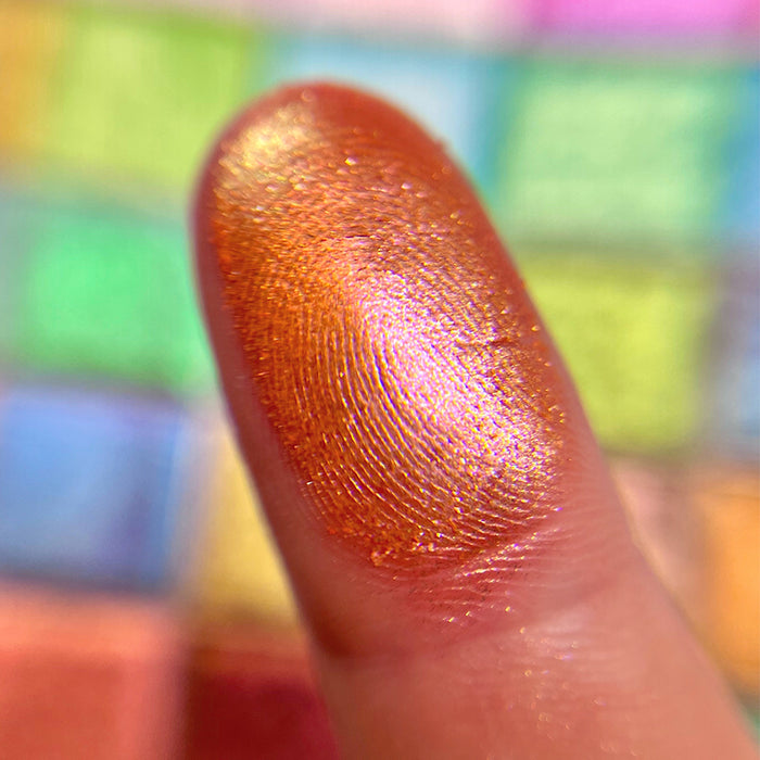 Close up finger swatch on fair skin tone of Court Jester Glitter Vibrant Multichrome Eyeshadow
