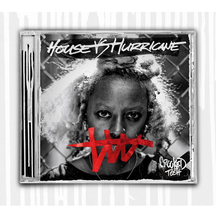 Picture of a CD Case. The cover is a photo of a woman's face, standing in front of a metal fence. The words "House VS Hurricane" are written in white marker along the top. Covering the woman's mouth is a squiggle with a horizontal line going through it. The bottom right corner says "Crooked Teeth" Drawn in marker.