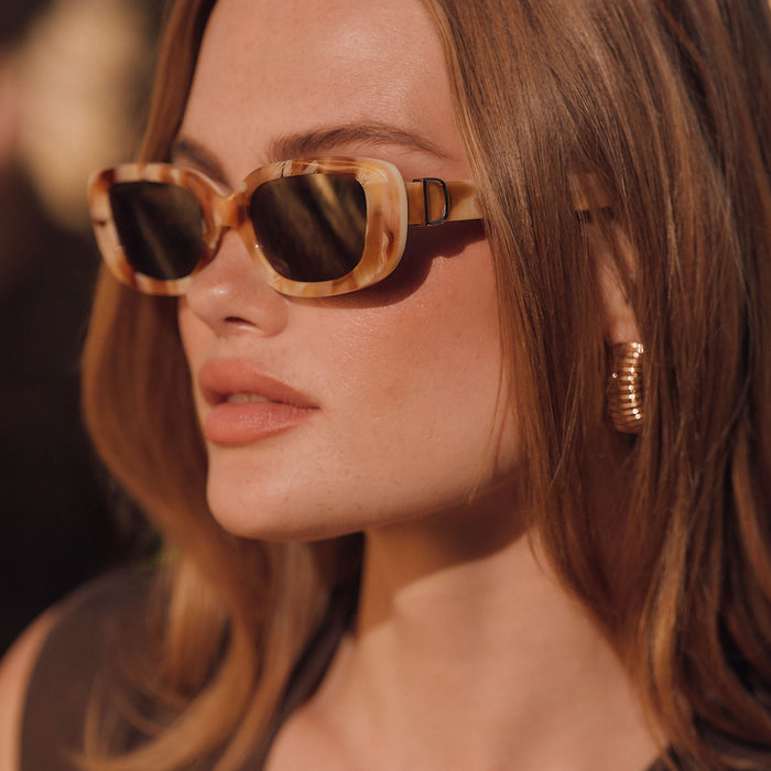 lifestyle - female wearing diff eyewear featuring the daphne rectangle sunglasses with a gilded tortoise outside and courtside ivory white inside acetate frame and brown polarized lenses angled view