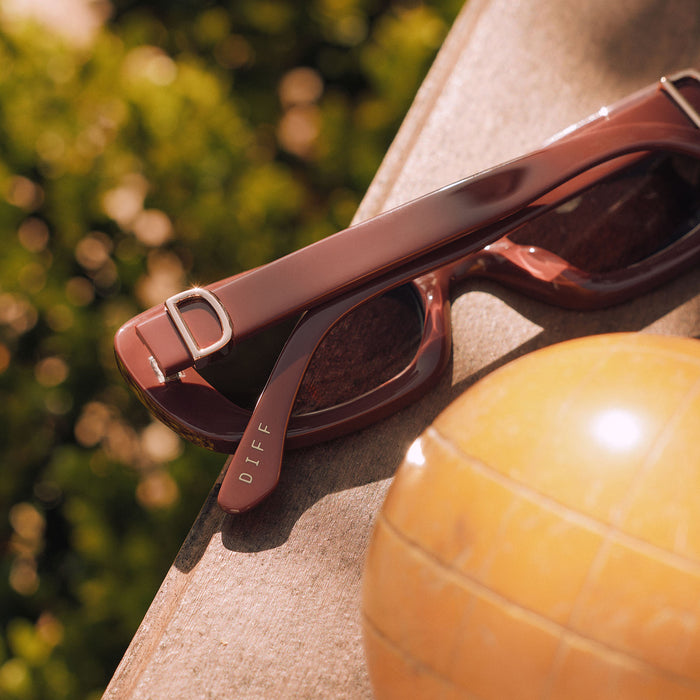 still life -  diff eyewear featuring the daphne rectangle sunglasses with a rugby red acetate frame and grey polarized lenses