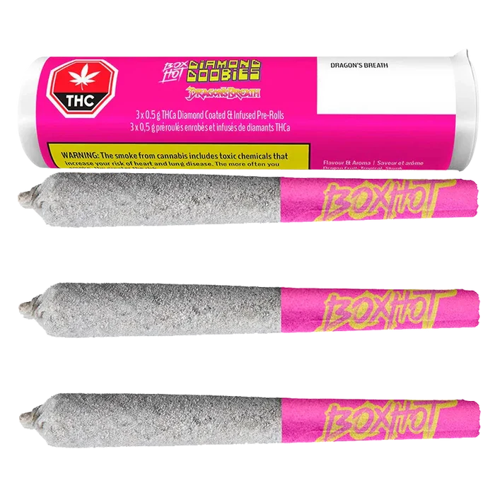 Three horizontal Diamond Doobies Dragon's Breath Infused PR 3 x 0.5 g pre-rolls coated in a sparkly silver layer with pink "BoxHot" tips beneath their matching pink cylindrical packaging.