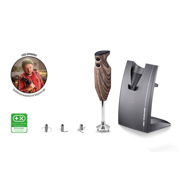 Der ESGE-Zauberstab Design Edition Nussbaum verfügt über einen Holzgriff, einen eleganten Ständer, drei Metallaufsätze, eine Zertifizierungsplakette und das runde Bild eines Kochs, der den Daumen nach oben zeigt, mit deutschem Text.