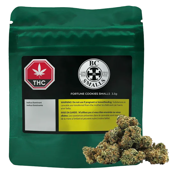 Front-facing green pouch labeled "Fortune Cookies Smalls" with a black product label, THC symbol, and cannabis buds piled at the lower right.