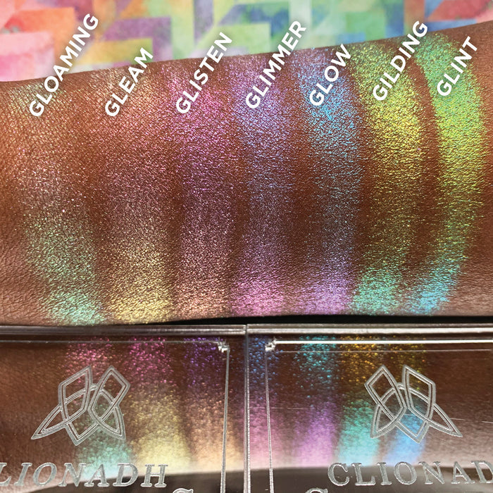 Straight angled arm swatches on deep skin tone of Glimmer Glitter-Type Iridescent Multichrome Eyeshadow shifts compared to Gloaming, Gleam, Glisten, Glow, Gilding, Glint
