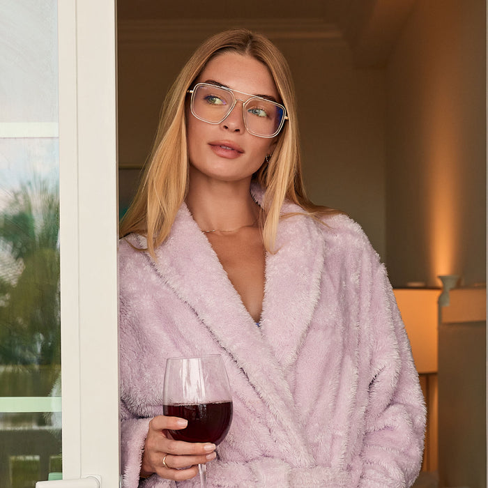 lifestyle - female looking at the beach with her diff eyewear featuring the jordan navigator prescription glasses with a gold frame, clear crystal temple tips front view