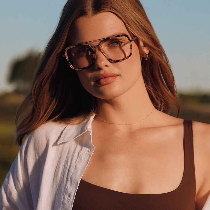 lifestyle - female outdoors wearing diff eyewear featuring the jordan navigator prescription glasses with a himalayan tortoise and gold metal frame angled view