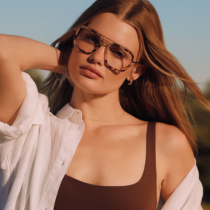 lifestyle - female outdoors wearing diff eyewear featuring the jordan navigator prescription glasses with a himalayan tortoise and gold metal frame front view