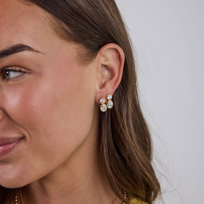 Woman wearing pearl earrings with a neutral background