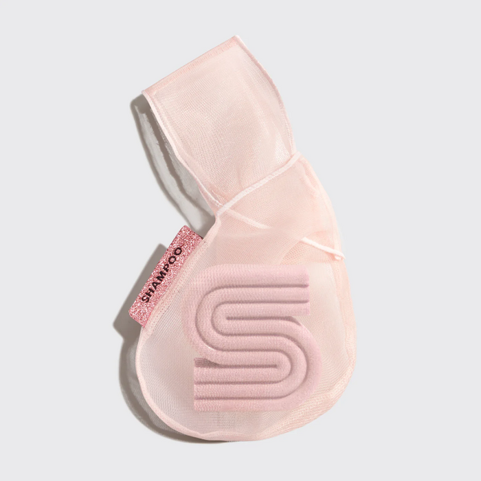 Pink shampoo bag with kitsch logo on a light gray background