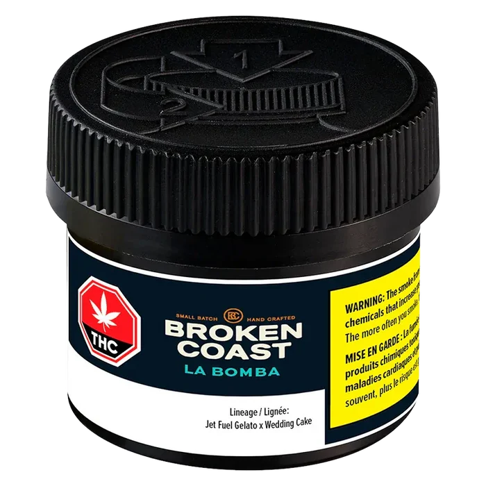 Close-up front view of the Broken Coast La Bomba jar showing its black ribbed lid, navy label and yellow warning panel.