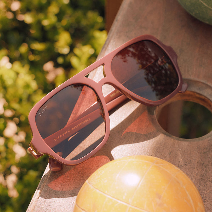 still life - diff eyewear layton in rugby red resting on a table next to bocce balls