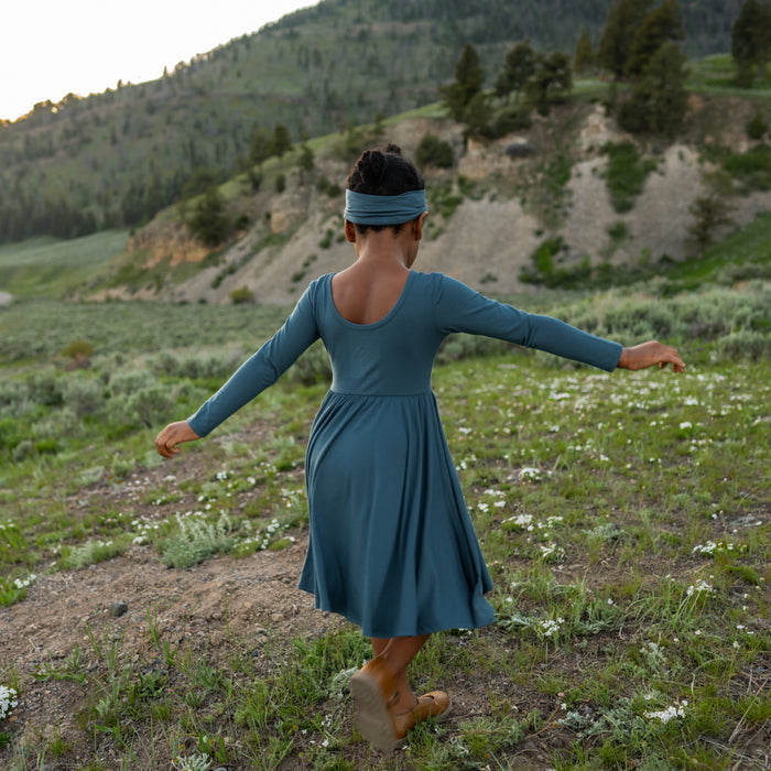 Ballerina back on the Long Sleeve Twirl Dress in Atlantic shown on a girl that is twirling in a field