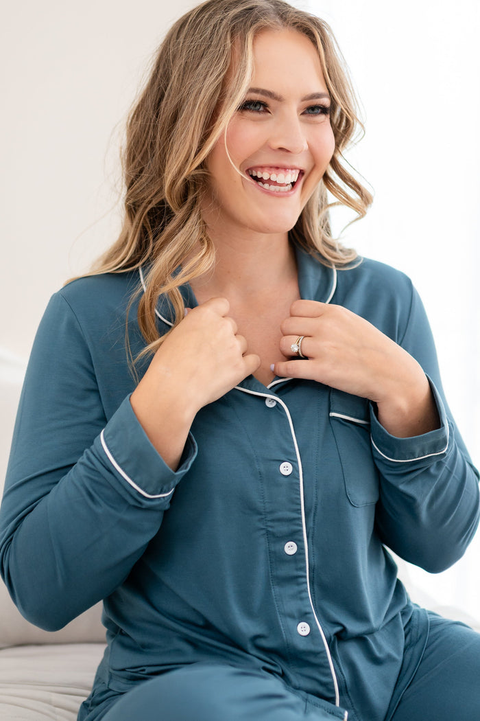 Smiling model wearing the Long-Sleeved Women's Pajama Set in Atlantic with Cloud Trim with focus on the button closure on the pajama top