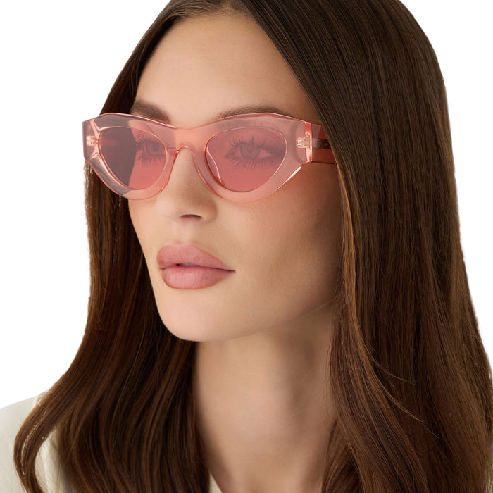 on model - female wearing for love & lemons x diff eyewear featuring the lucy cat eye sunglasses with a pastel pink acetate frame and rose pink lenses angled view