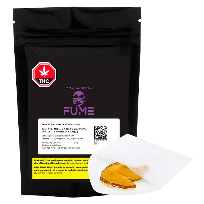 Front-facing shot of a black pouch labeled "Max Exhaust Haze Shatter" with purple FUME logo and a piece of amber shatter on white parchment in the foreground