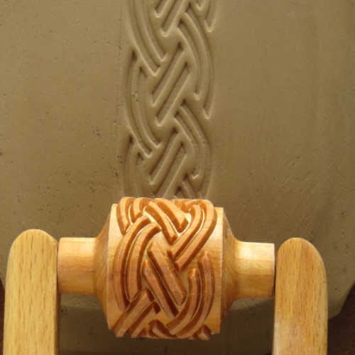 MKM Medium Handle Roller in the Braid pattern rolled through grey clay, leaving a braided band