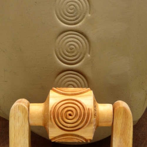 MKM Medium Handle Roller in the Spiral pattern, a row of round spirals impressed in grey clay