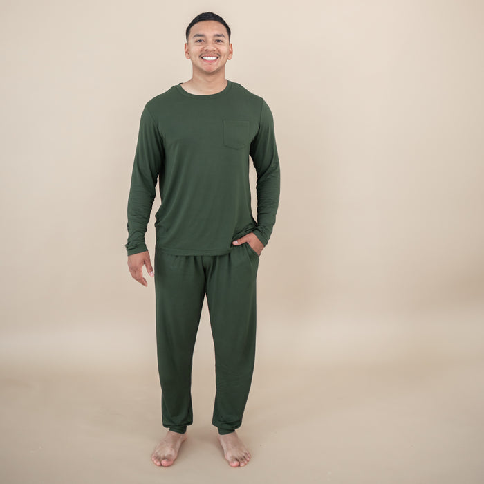 Man wearing a Men's Jogger Set in Fir against a beige background