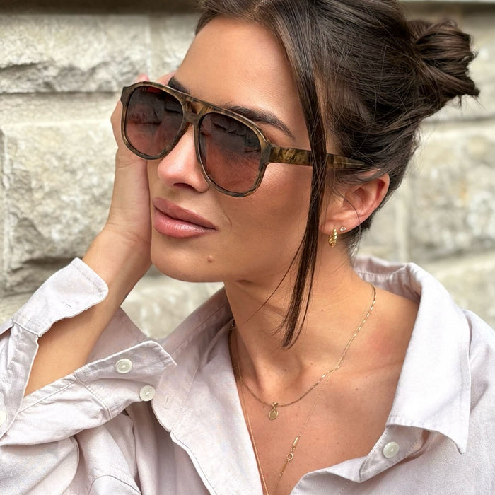 on model - jessie james decker wearing diff eyewear nash navigator sunglasses with a black walnut tortoise frame and brown gradient lenses angled view