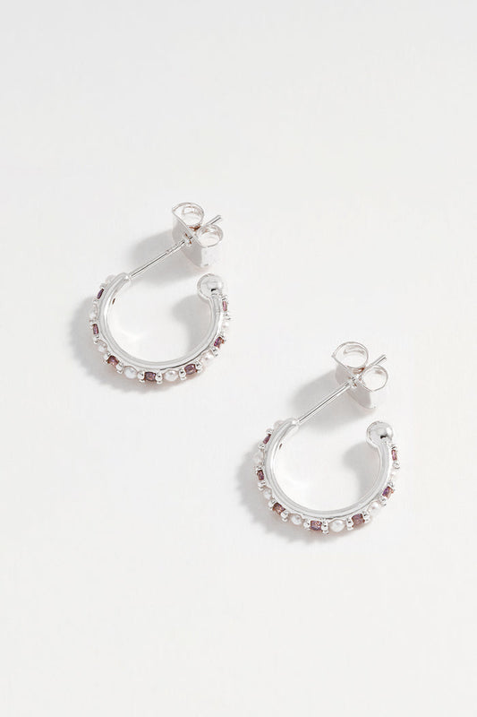 Pair of silver hoop earrings with small stones on a white background
