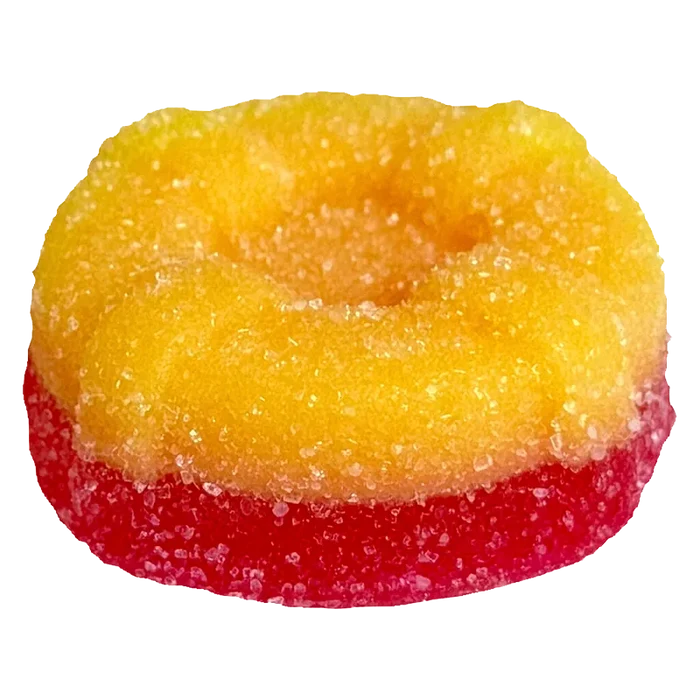 Close-up of a two-toned sugar-coated gummy in yellow over red, photographed from slightly above, showing texture and a shallow center, Ratio'd Tropic Boost Gummies