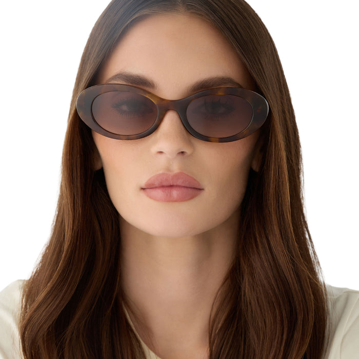 on model - female wearing for love & lemons x diff eyewear featuring the sabrina oval sunglasses with a honey tortoise acetate frame and brown gradient lenses front view