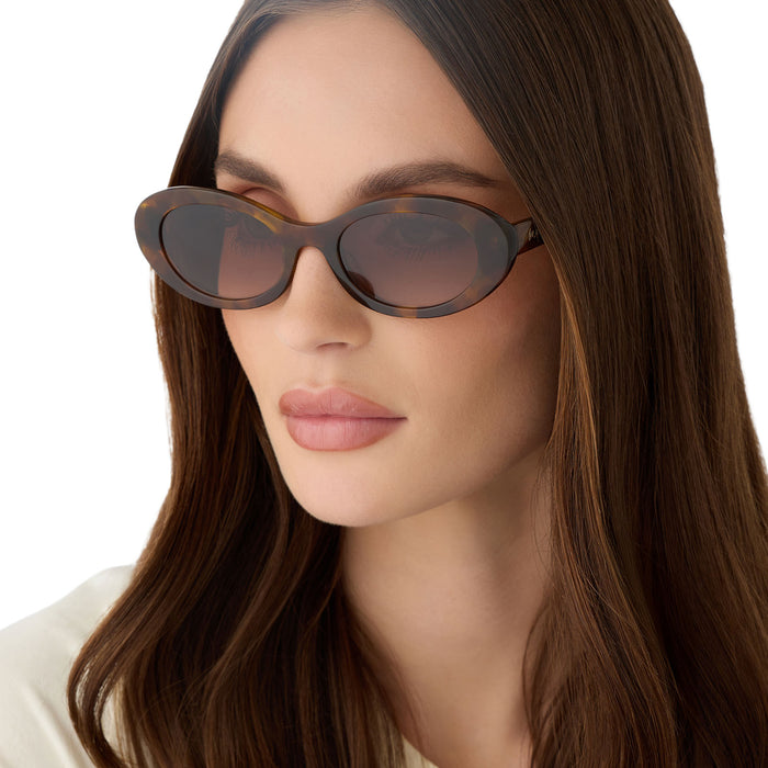 on model - female wearing for love & lemons x diff eyewear featuring the sabrina oval sunglasses with a honey tortoise acetate frame and brown gradient lenses angled view