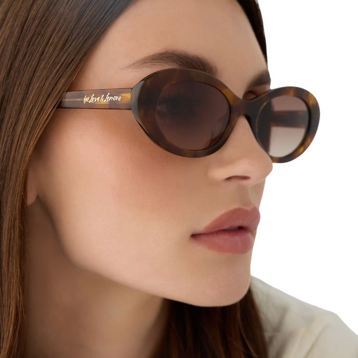 on model - female wearing for love & lemons x diff eyewear featuring the sabrina oval sunglasses with a honey tortoise acetate frame and brown gradient lenses detailed view