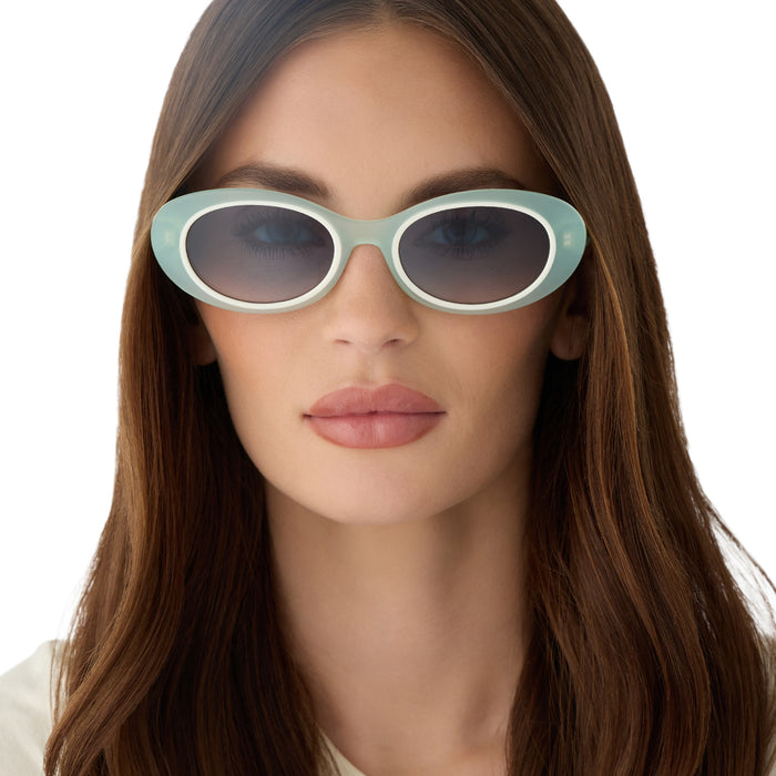 on model - female wearing for love & lemons x diff eyewear featuring the sabrina oval sunglasses with a pastel sage acetate frame and blue gradient lenses front view