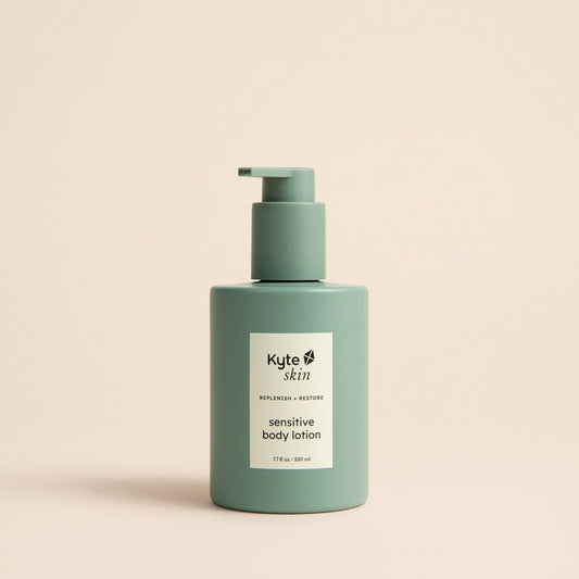 Green bottle of Kyle skin sensitive body lotion on a beige background