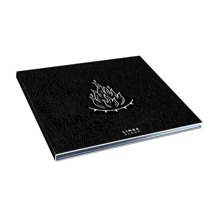 A black hardcover LIMBS book features a white outline campfire on the cover with abstract black textures. The spine reads "LINES," and the back has a subtle track list motif. Photographed against a white background.