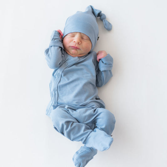 Baby in a take me home set with kimono style top, footie pants and cap in a slate blue