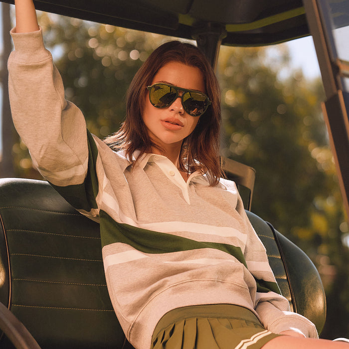 lifestyle - female in a golf cart wearing diff eyewear featuring the tosca iii aviator sunglasses with a fairway green acetate with gold accentsframe  and aloe green gradient w/ light gold flash lenses