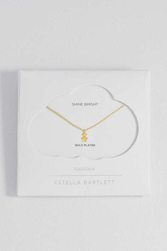 Gold necklace on a white box with 'Estella Bartlett' branding