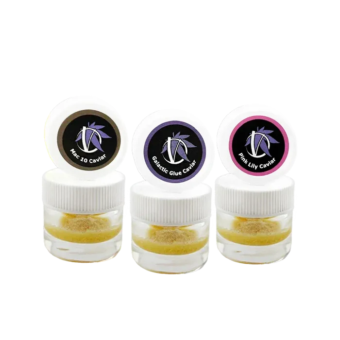 Three small clear jars photographed front-on with white lids and colored logo stickers, labeled Virtue Caviar Flight Caviar.