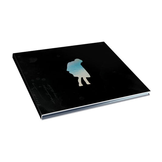 A black hardcover Special Edition book by I The Mighty lies closed on a white surface, its cover displaying a silhouetted figure against a gradient blue-and-white background.