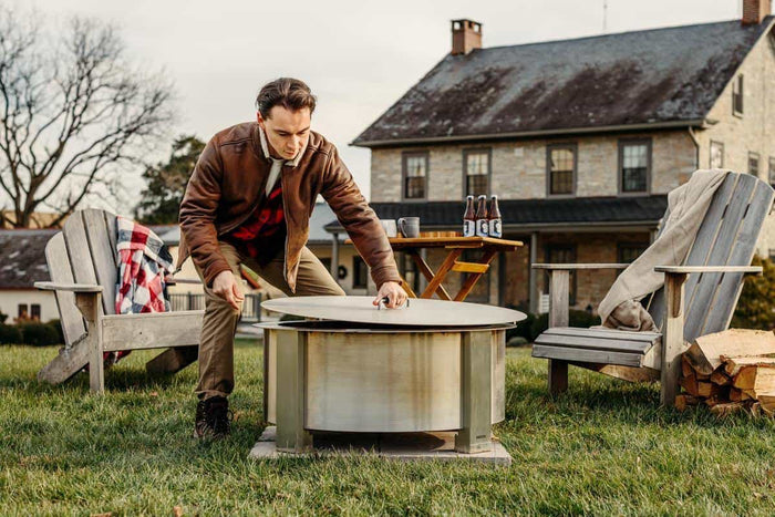 This is an image of a man removing the lid from the X30 firepit