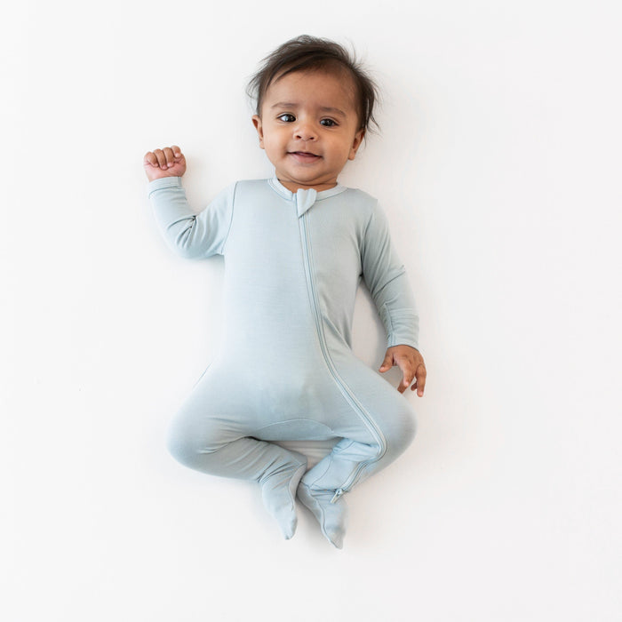 Infant wearing Zippered Footie in Fog while laying on a white surface